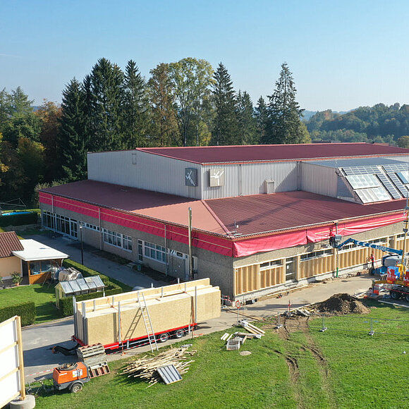 Sanierung Gewerbe und Holzrahmenbau Baustelle, Turnhalle mit Kran und Materialien